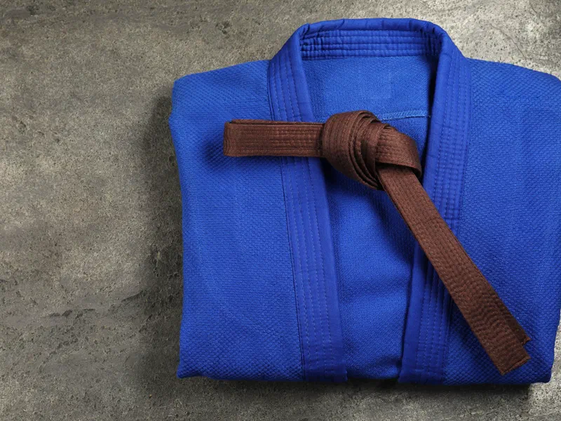 A folded blue gi with a brown belt, seen from above