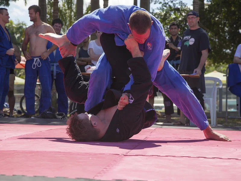 A grappler on his back controls a standing opponent from guard